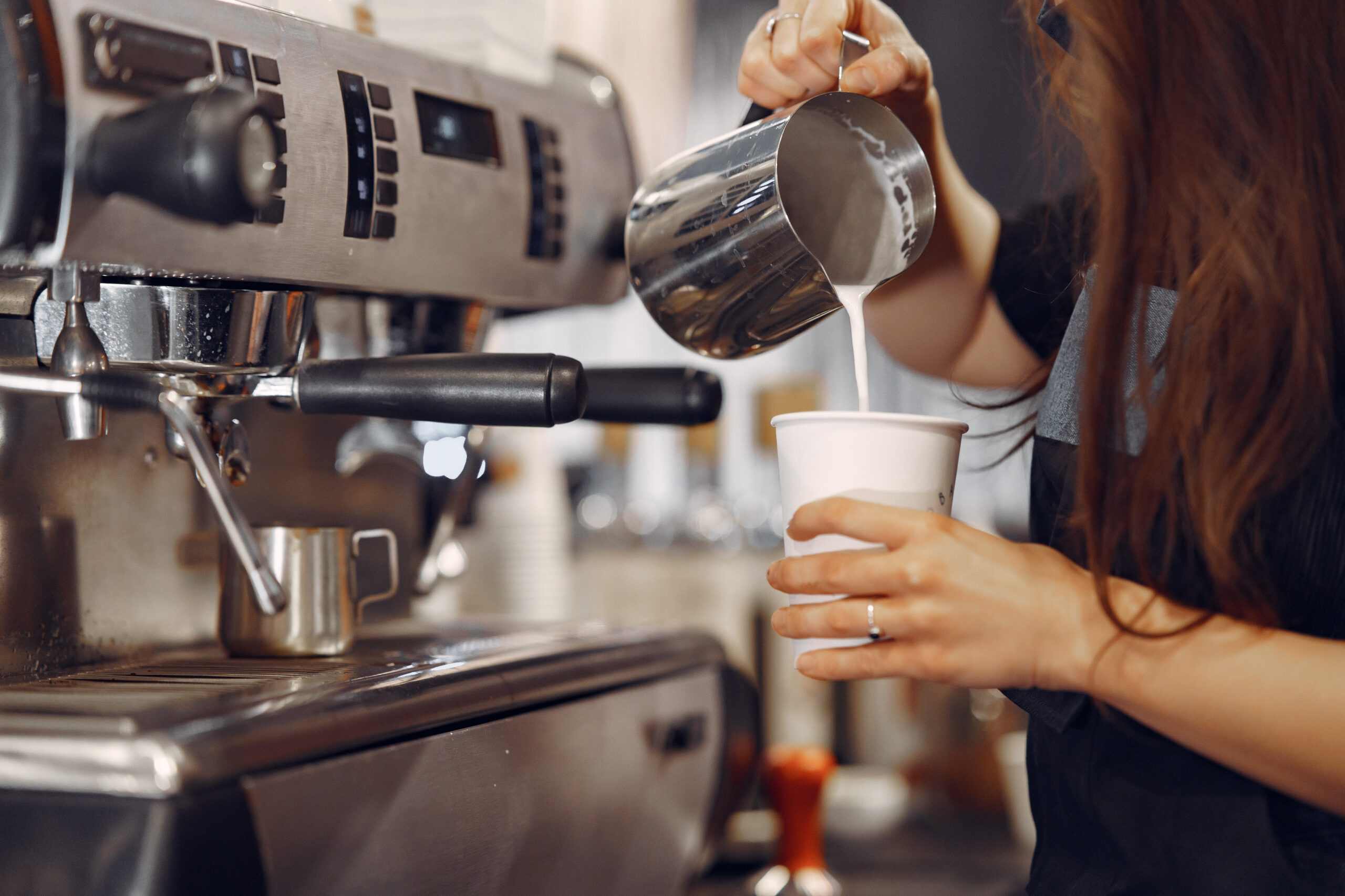 una persona poniendo café en una cafetería